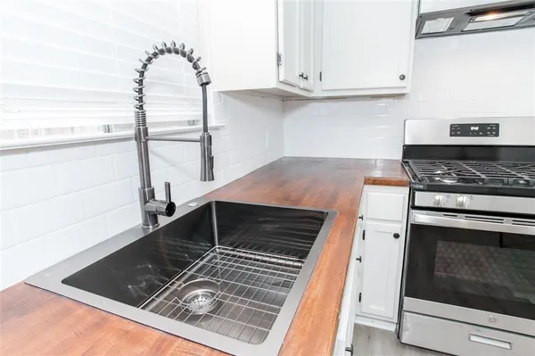 a kitchen with granite countertop a stove and a sink