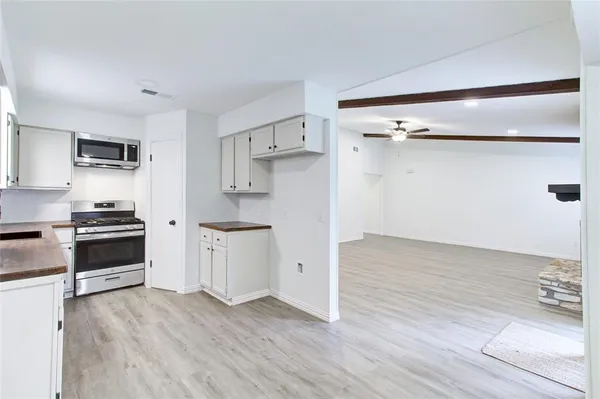 a kitchen with granite countertop a refrigerator and a stove top oven