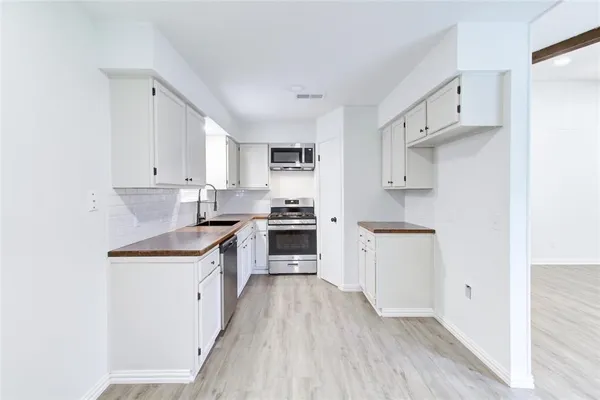 a kitchen with white cabinets appliances and sink
