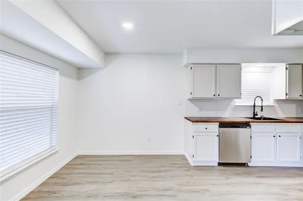 a kitchen with granite countertop a sink cabinets and wooden floor
