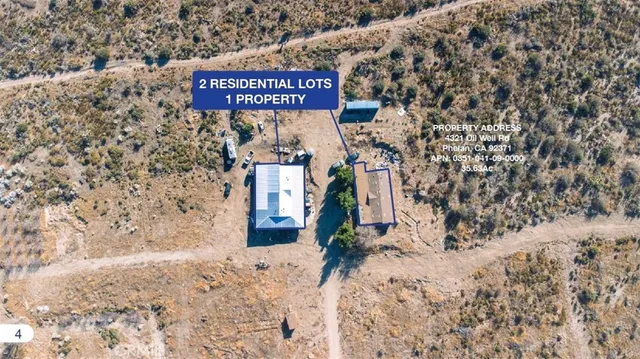 a view of a dry yard with wooden fence