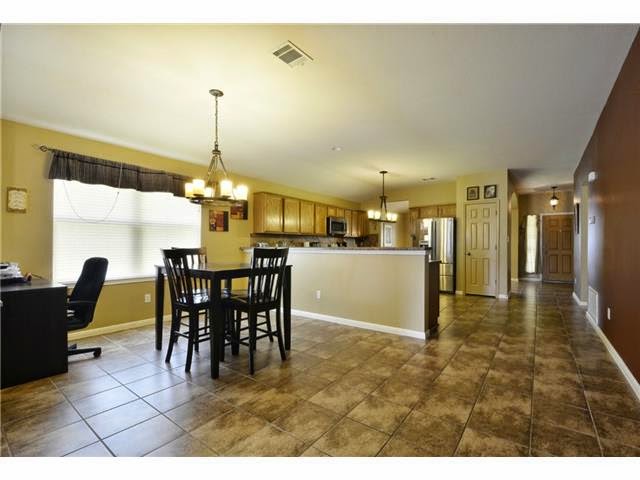 11612 Timber Heights Drive Austin, TX 78754 - Photo 18 of 28 A well-lit, open-concept area connects the kitchen and dining space, perfect for everyday living.