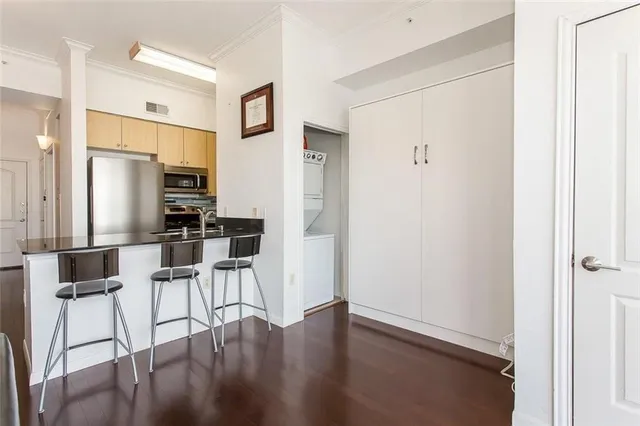a kitchen with stainless steel appliances wooden floor and a refrigerator