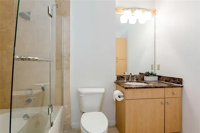 a bathroom with a granite countertop sink toilet and shower