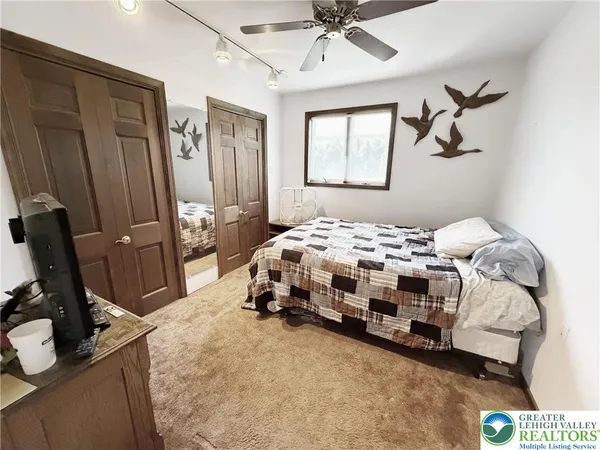 a bedroom with a bed a dresser and potted plants