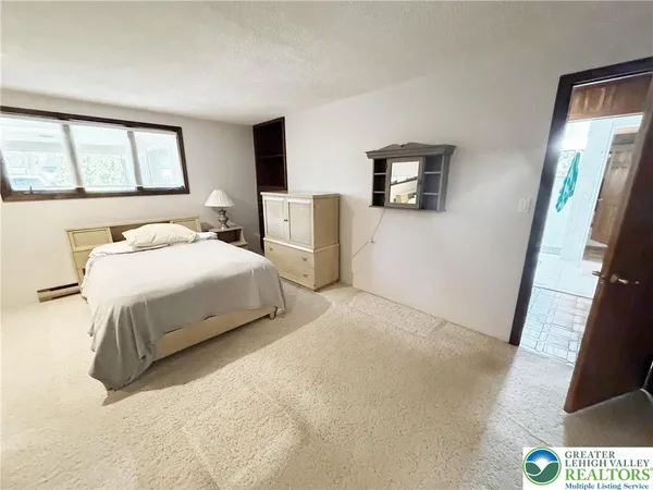 a bedroom with a bed and dresser with mirror