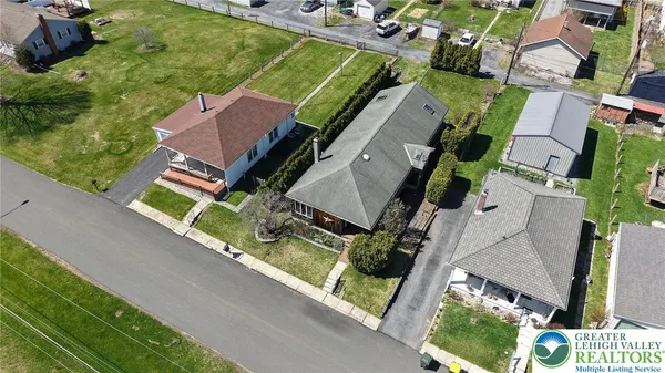 an aerial view of a house with garden space and street view