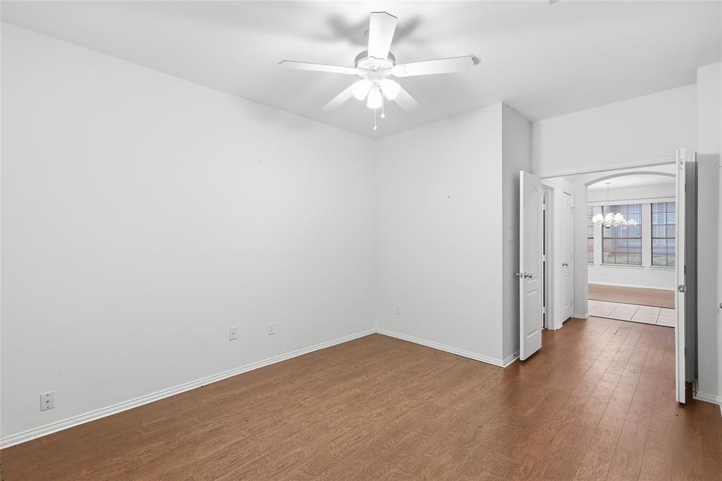 2216 Post Oak Court Corinth, TX 76210 - Photo 12 of 19 an empty room with wooden floor fan and windows