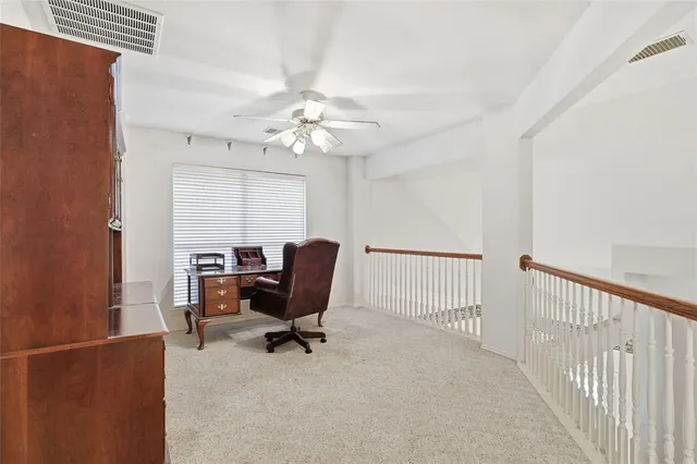 an empty room with a window and a ceiling fan