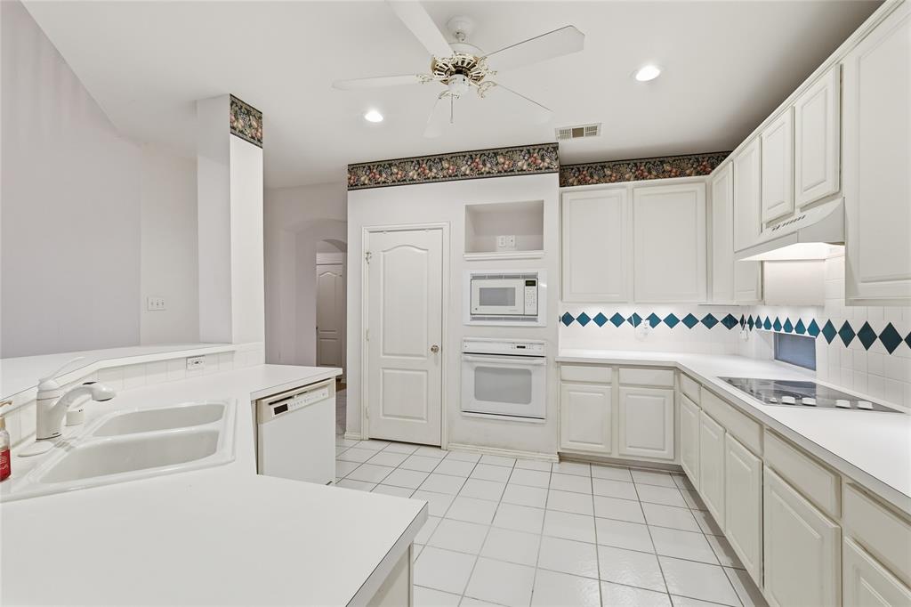 2216 Post Oak Court Corinth, TX 76210 - Photo 6 of 19 a kitchen with granite countertop cabinets and white appliances