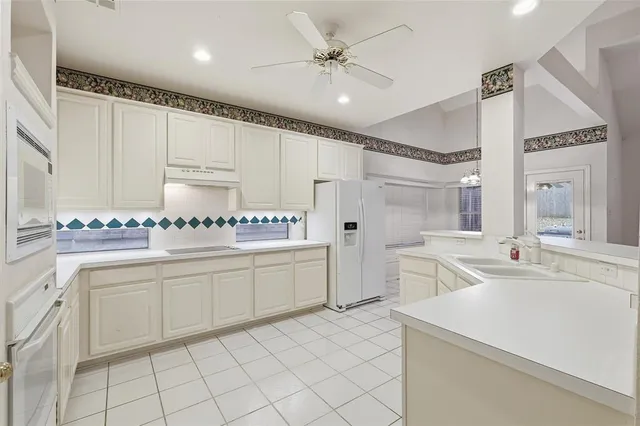 a kitchen with granite countertop cabinets and white appliances