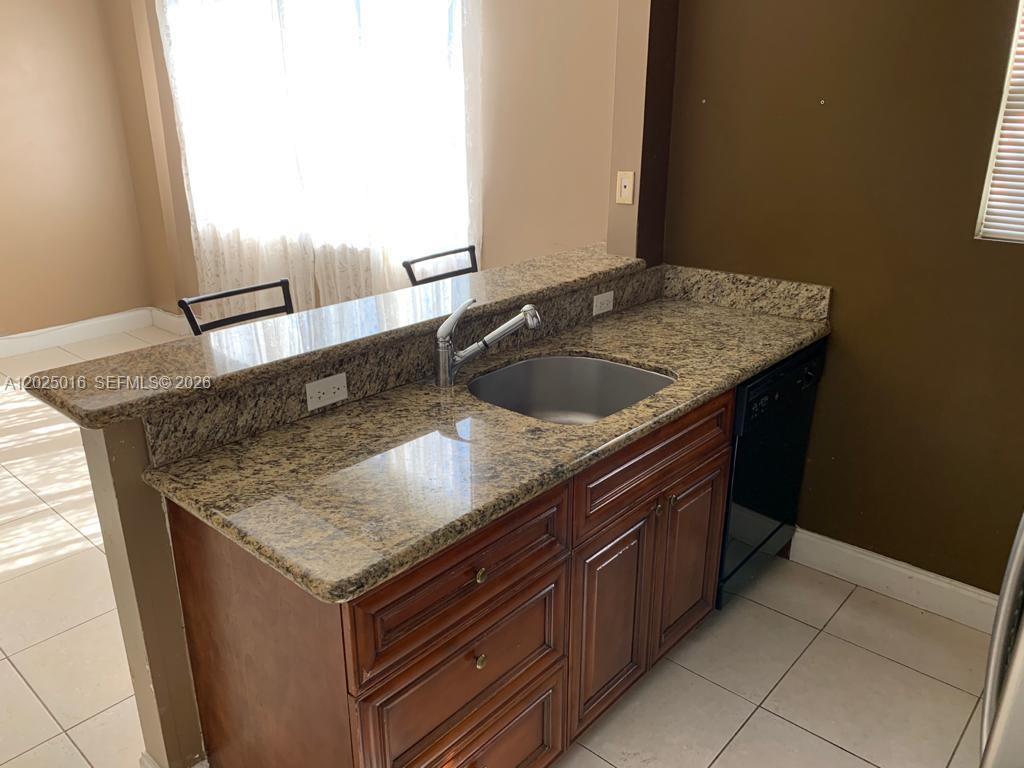 400 Southwest 2nd Street, Unit 201 Miami, FL 33130 - Photo 5 of 12 a kitchen with a granite countertop sink and dishwasher