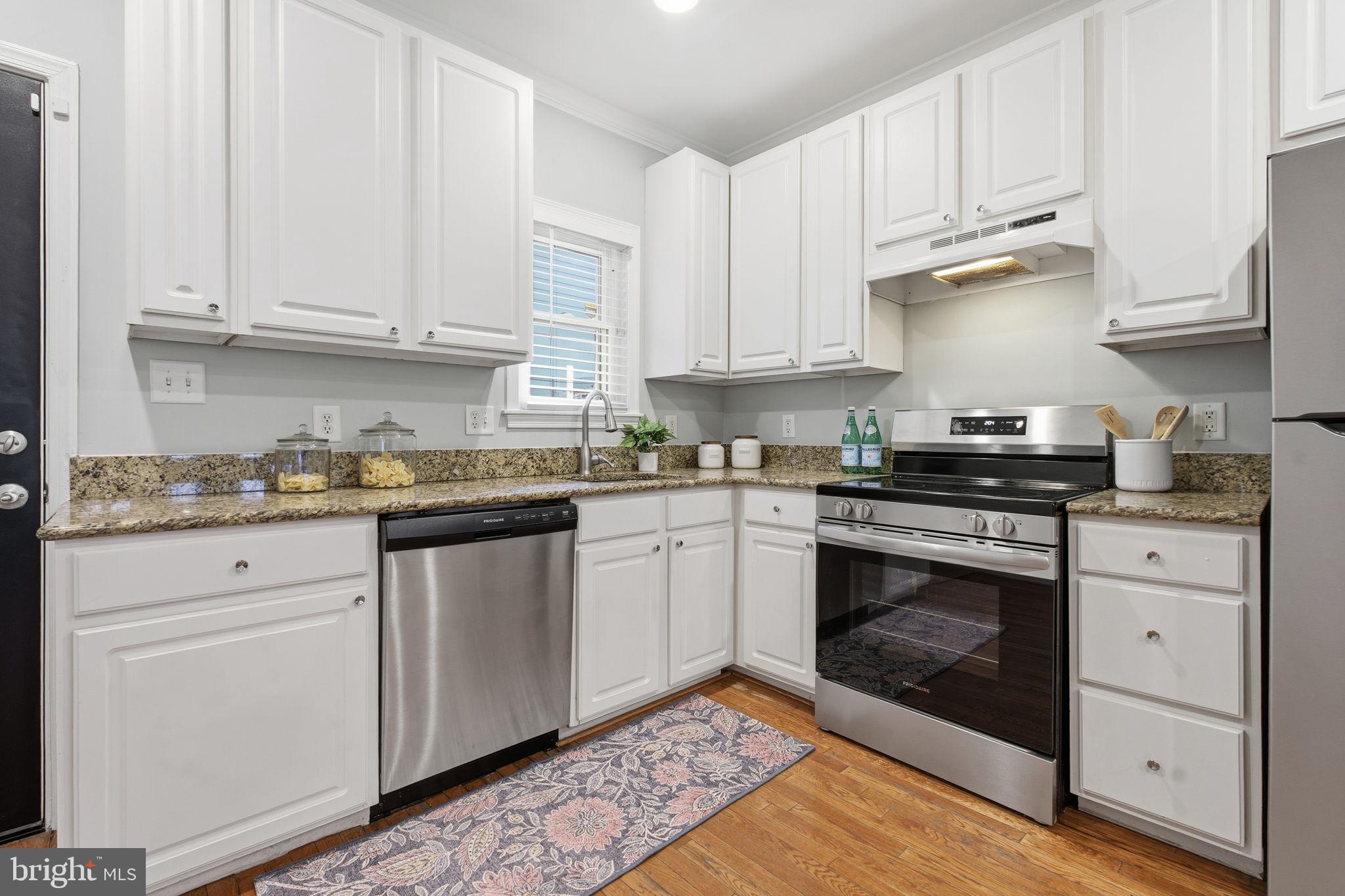3135 Fait Avenue Baltimore, MD 21224 - Photo 6 of 35 a kitchen with granite countertop white cabinets and stainless steel appliances