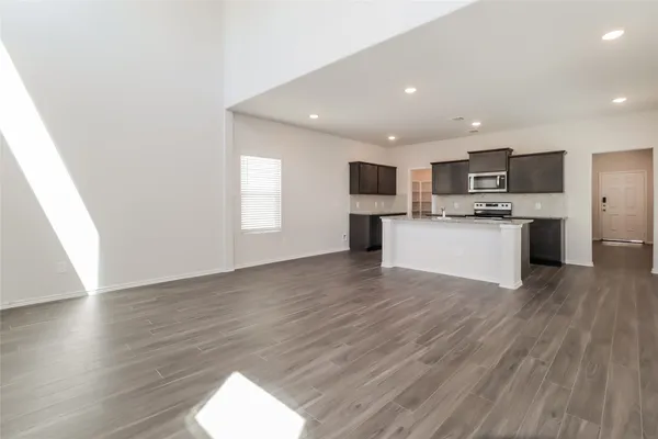 a view of kitchen with microwave a stove and wooden floor