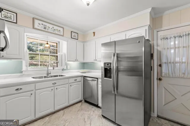 a kitchen with a refrigerator sink and cabinets