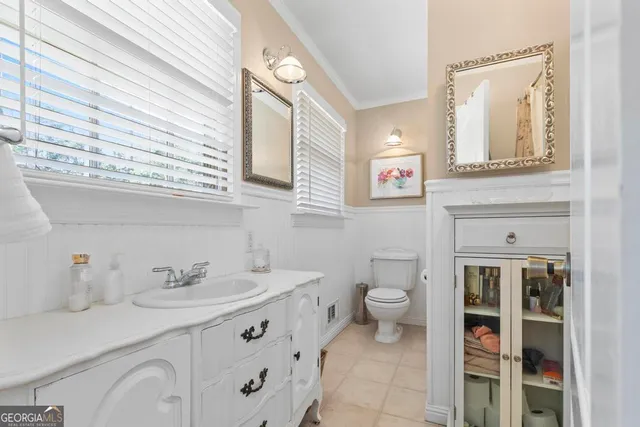 a bathroom with a sink a toilet and a mirror