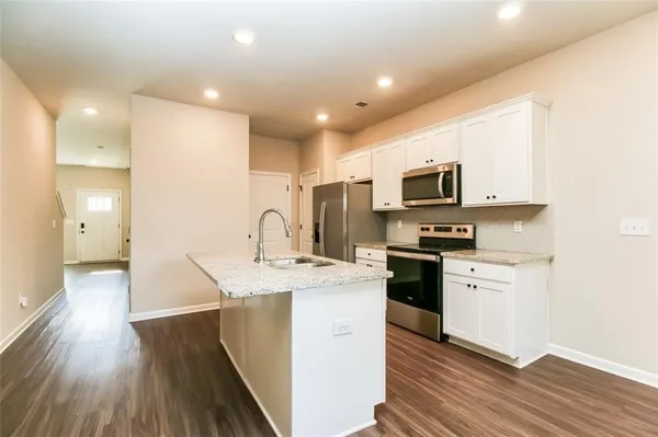 a kitchen with stainless steel appliances granite countertop a sink a stove top oven a counter space and cabinets