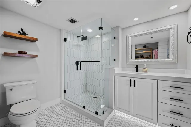 a bathroom with a toilet a sink a glass door and shower