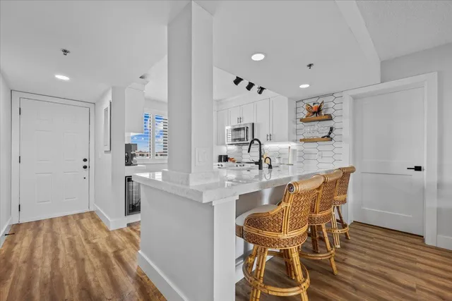 a kitchen with stainless steel appliances granite countertop a sink and a refrigerator