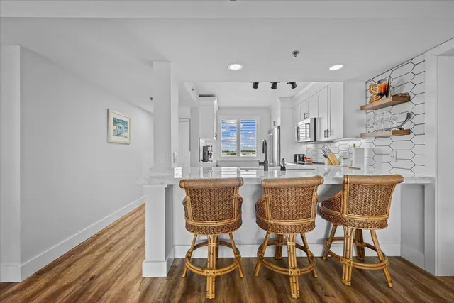 a dining hall with stainless steel appliances a dining table and chairs with wooden floor