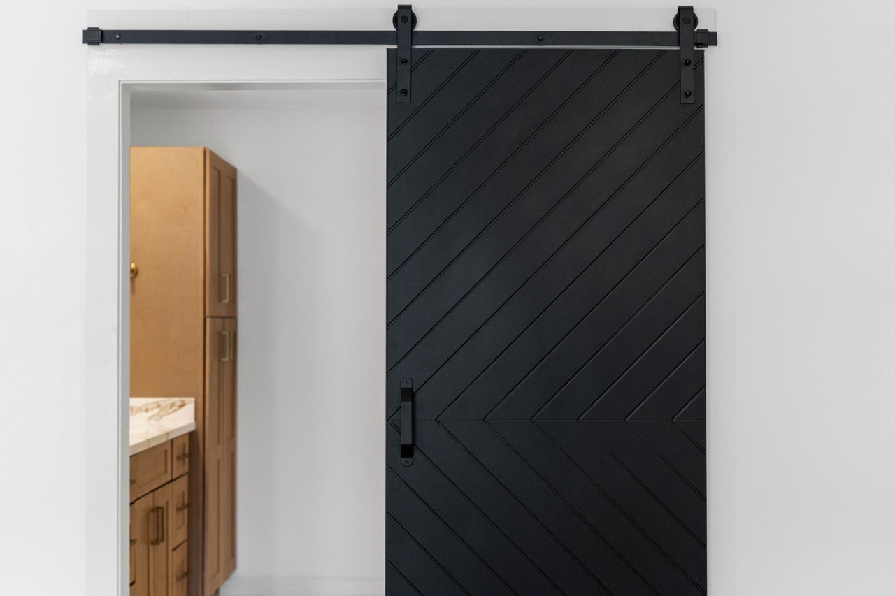 5326 Findlay Drive Pasadena, TX 77505 - Photo 32 of 50 Stylish black chevron barn door adds a custom designer touch to the primary suite bathroom entrance.