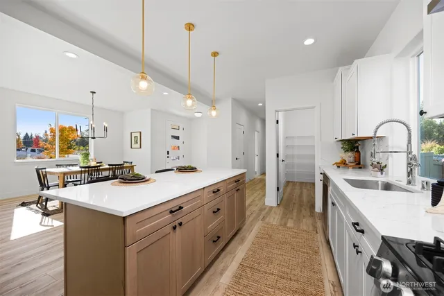a kitchen with kitchen island a sink stove and wooden floor