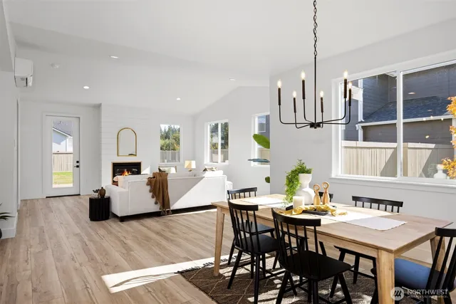 a view of dining room and livingroom with furniture wooden floor a chandelier