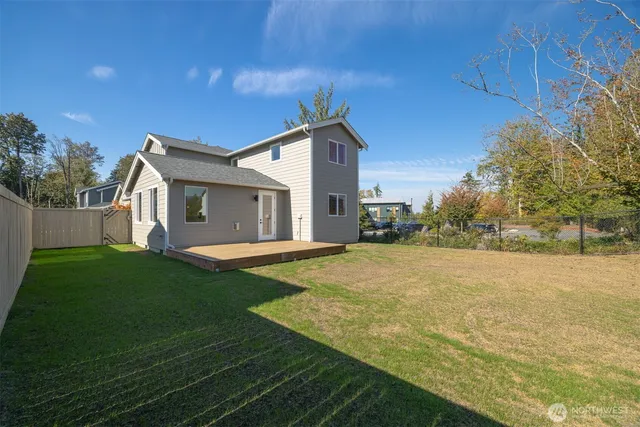 a view of an house with backyard and trees