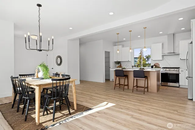 a view of a dining room and livingroom with furniture wooden floor a chandelier