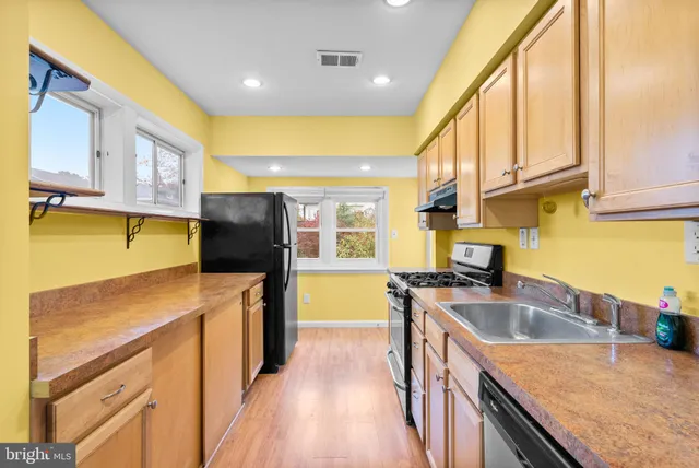 a kitchen that has a sink a stove and a oven