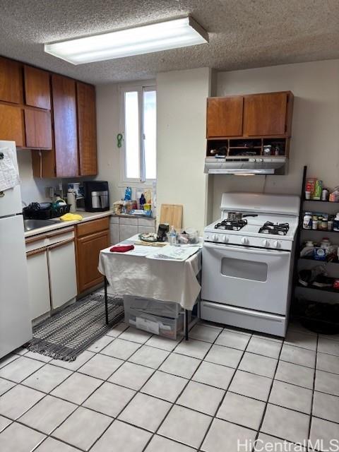 454 Nāmāhana Street, Unit 501 Honolulu, HI 96815 - Photo 2 of 5 a kitchen with a sink a stove and cabinets