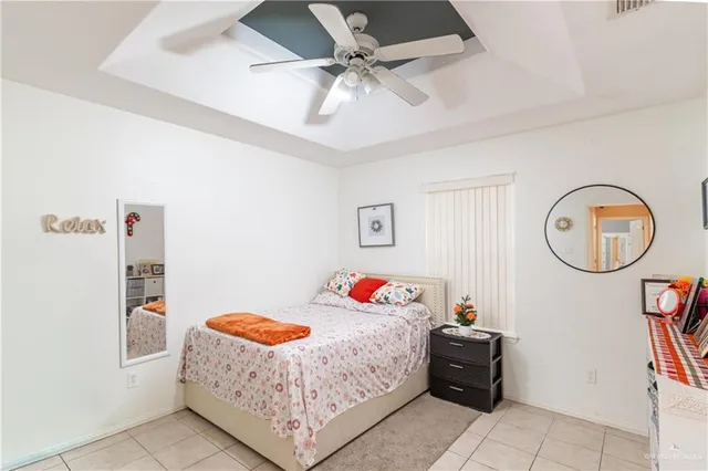 a bedroom with a bed a clock and a ceiling fan