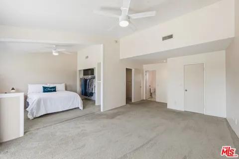 a spacious bedroom with a bed and a couch