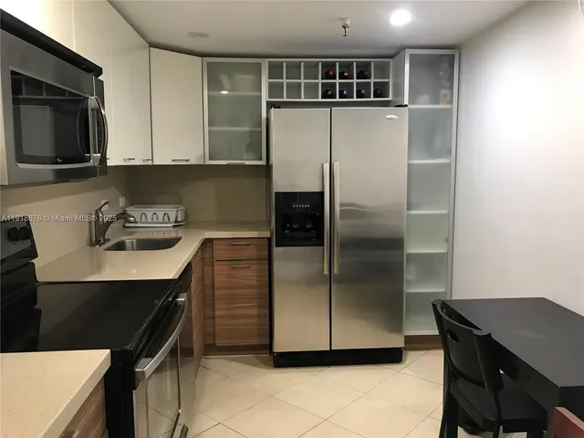 a kitchen with a refrigerator and a stove top oven