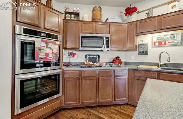 a kitchen with stainless steel appliances granite countertop a stove microwave and sink