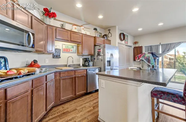 a kitchen with stainless steel appliances granite countertop a sink dishwasher and cabinets with wooden floor