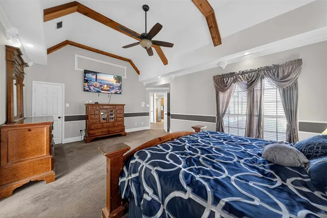 a bedroom with a bed and dresser with mirror