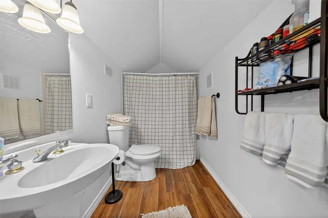 a bathroom with a sink a toilet a mirror and shower