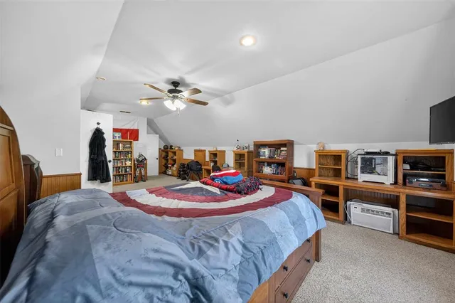 a spacious bedroom with a bed and a chandelier