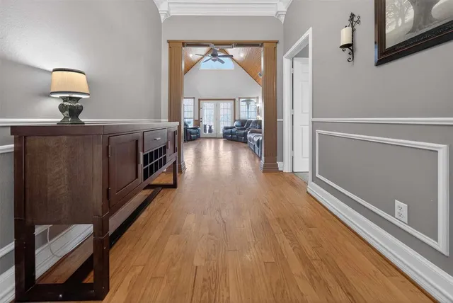 a view of a hallway with wooden floor and livingroom
