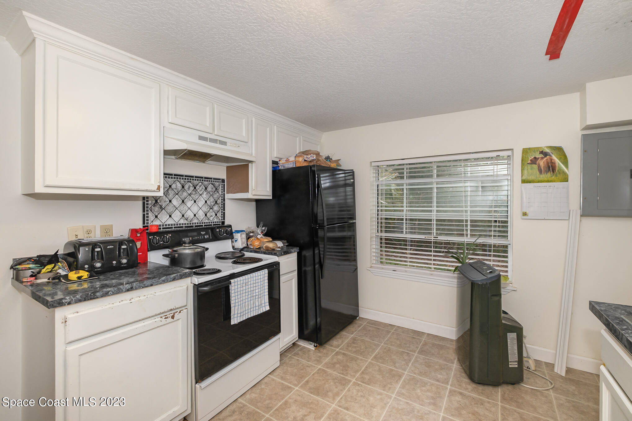 1826 Lemay Drive Northeast Palm Bay, FL 32905 - Photo 23 of 31 a kitchen with a stove top oven and cabinets