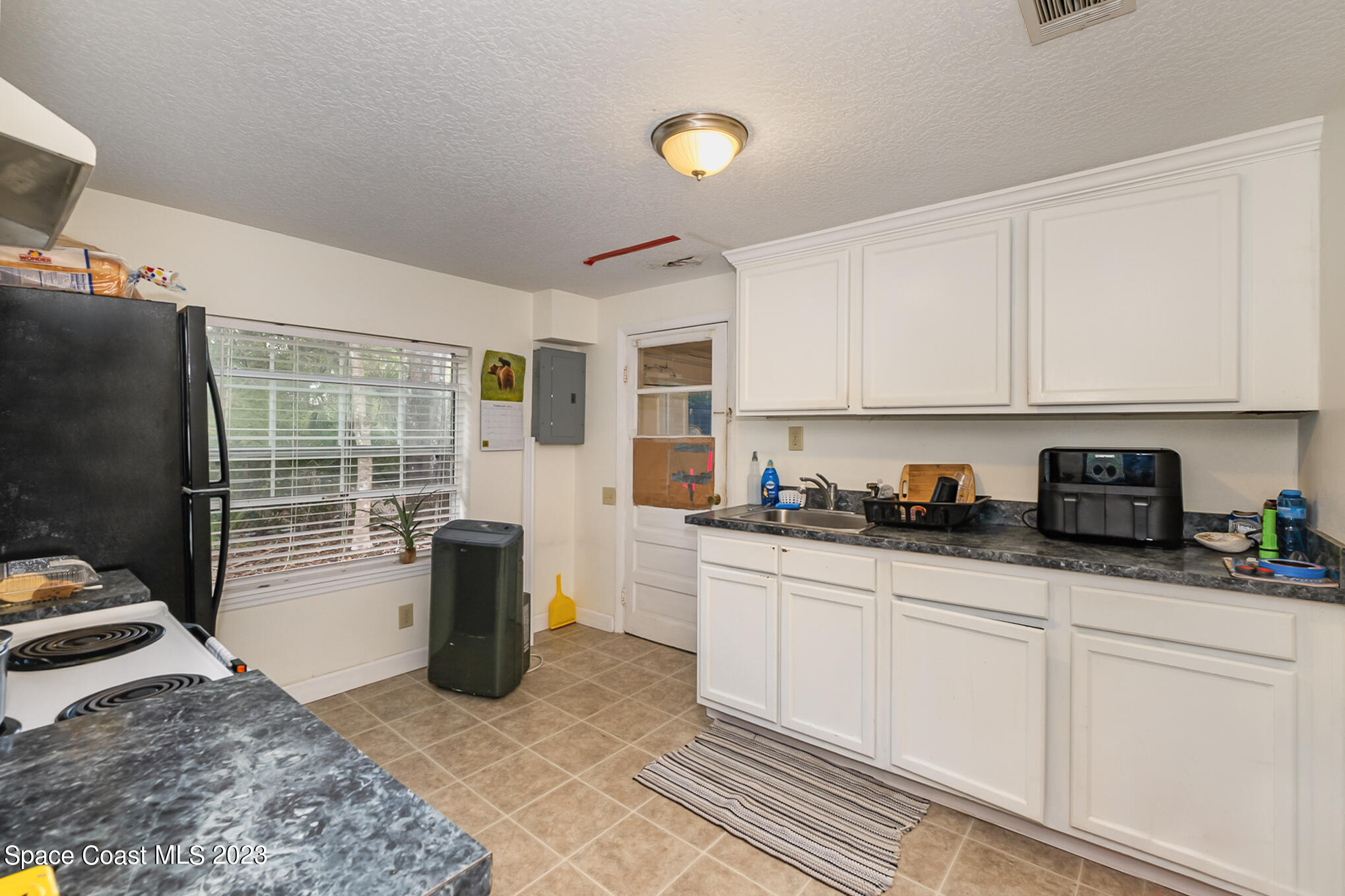 1826 Lemay Drive Northeast Palm Bay, FL 32905 - Photo 24 of 31 a kitchen with a refrigerator and a stove top oven