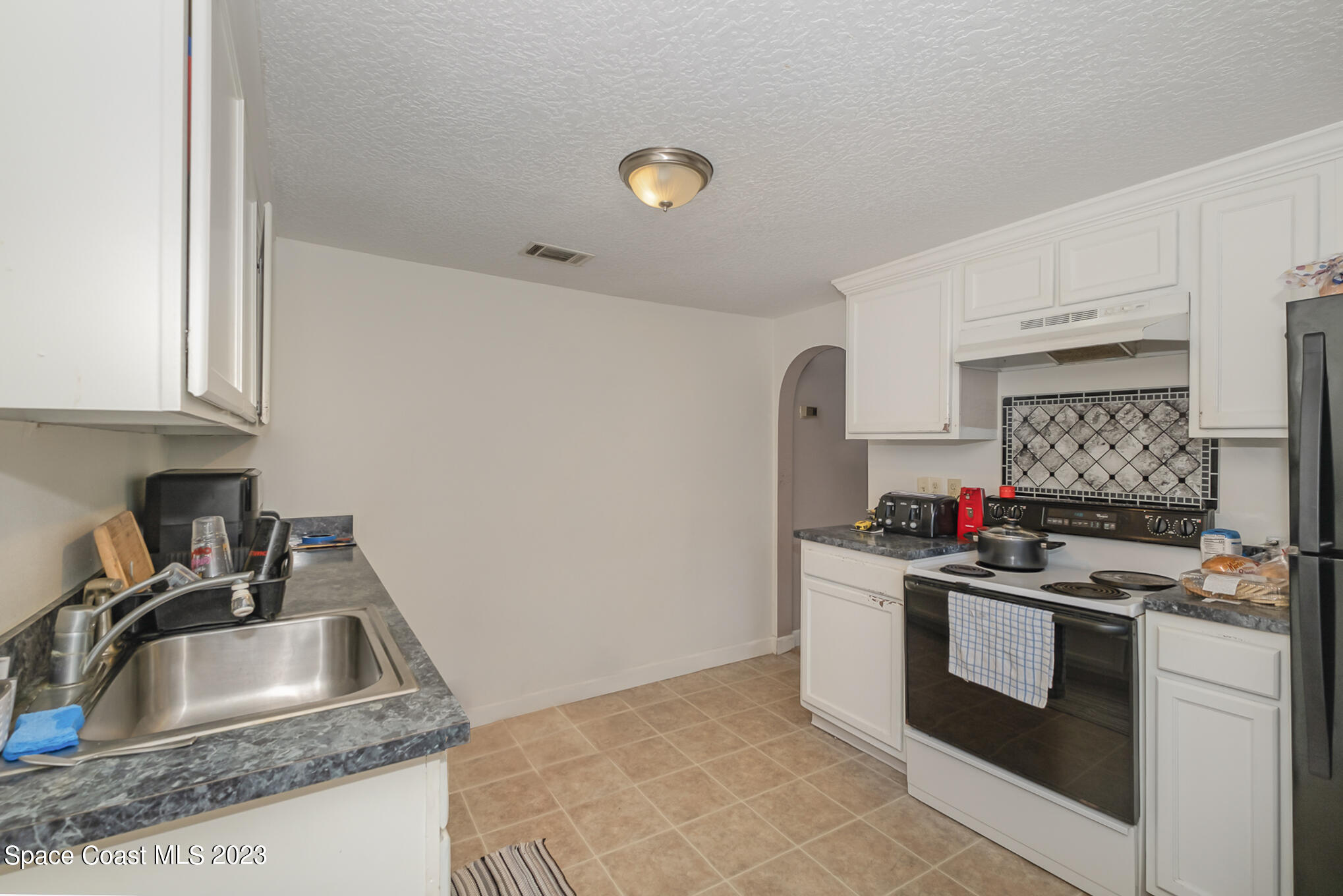 1826 Lemay Drive Northeast Palm Bay, FL 32905 - Photo 25 of 31 a kitchen with stainless steel appliances granite countertop a sink stove and refrigerator