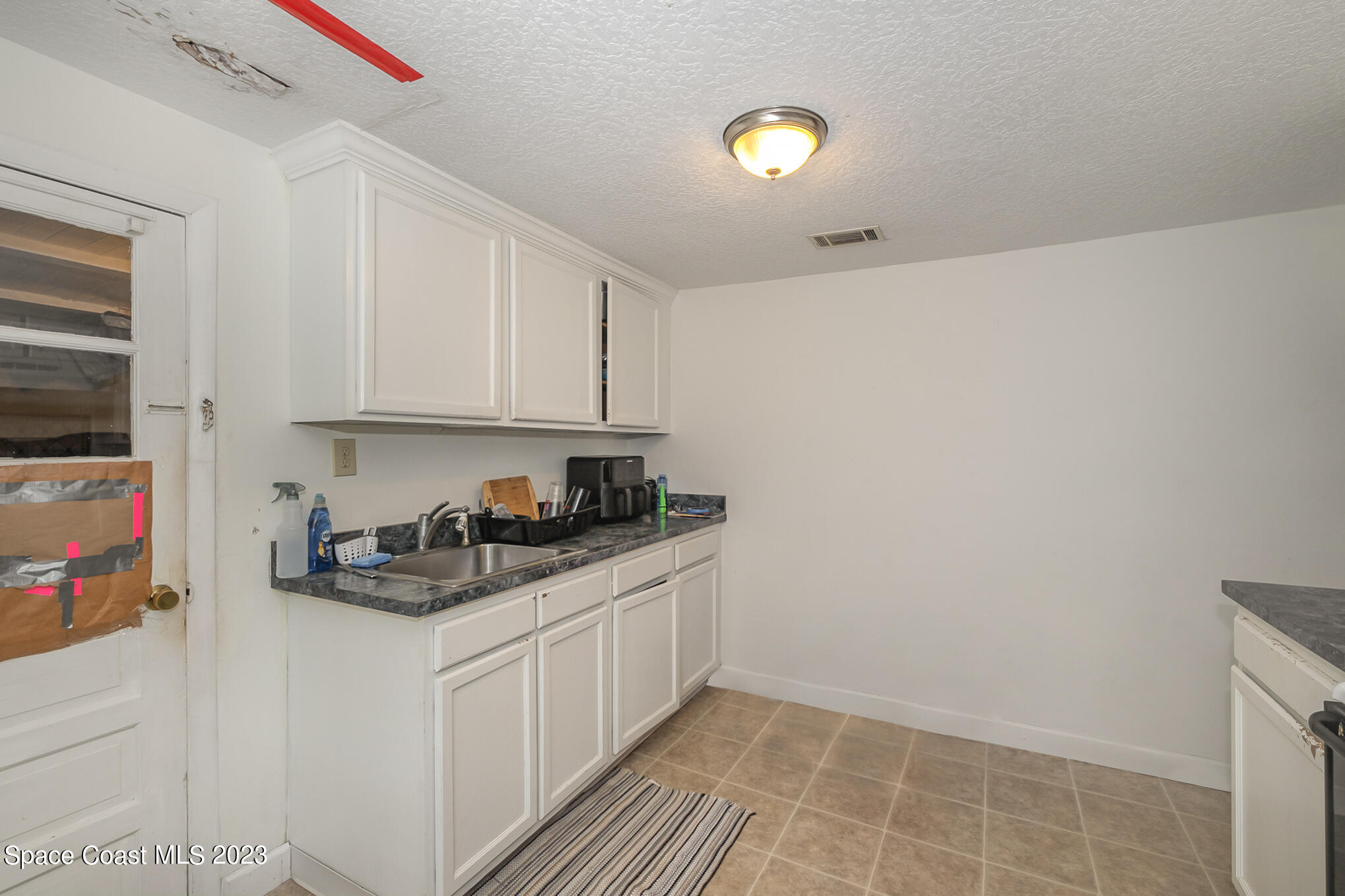 1826 Lemay Drive Northeast Palm Bay, FL 32905 - Photo 26 of 31 a kitchen with stainless steel appliances a sink a stove a microwave and cabinets