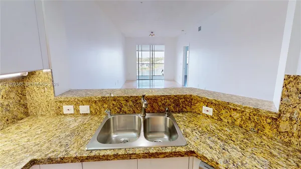 a kitchen with granite countertop a refrigerator and a stove