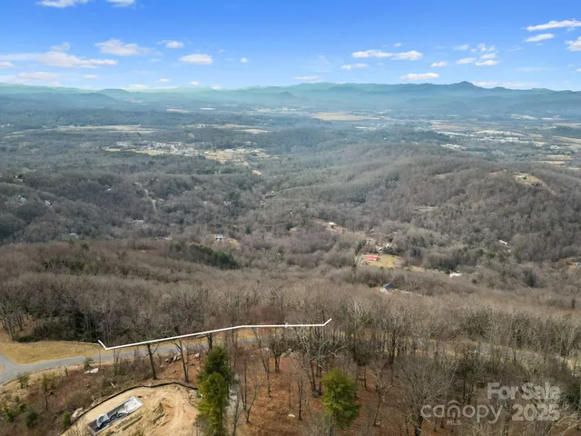 a view of a dry yard with wooden fence