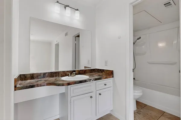 a bathroom with a granite countertop sink and a mirror