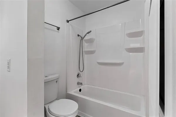 a bathroom with a toilet and a shower