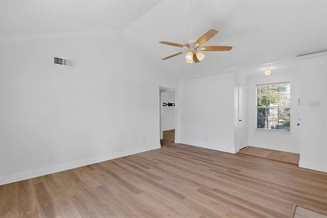 a view of empty room with wooden floor