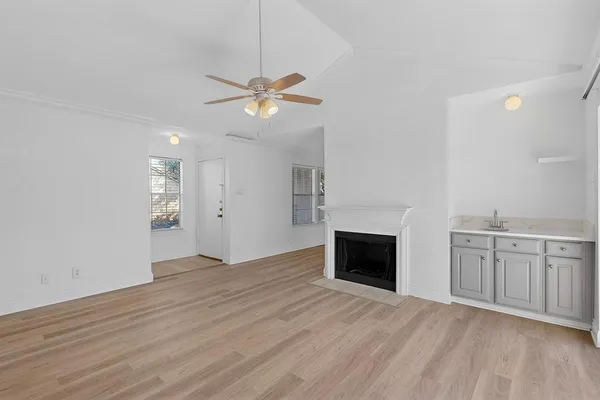 a view of an empty room with a fireplace and a window